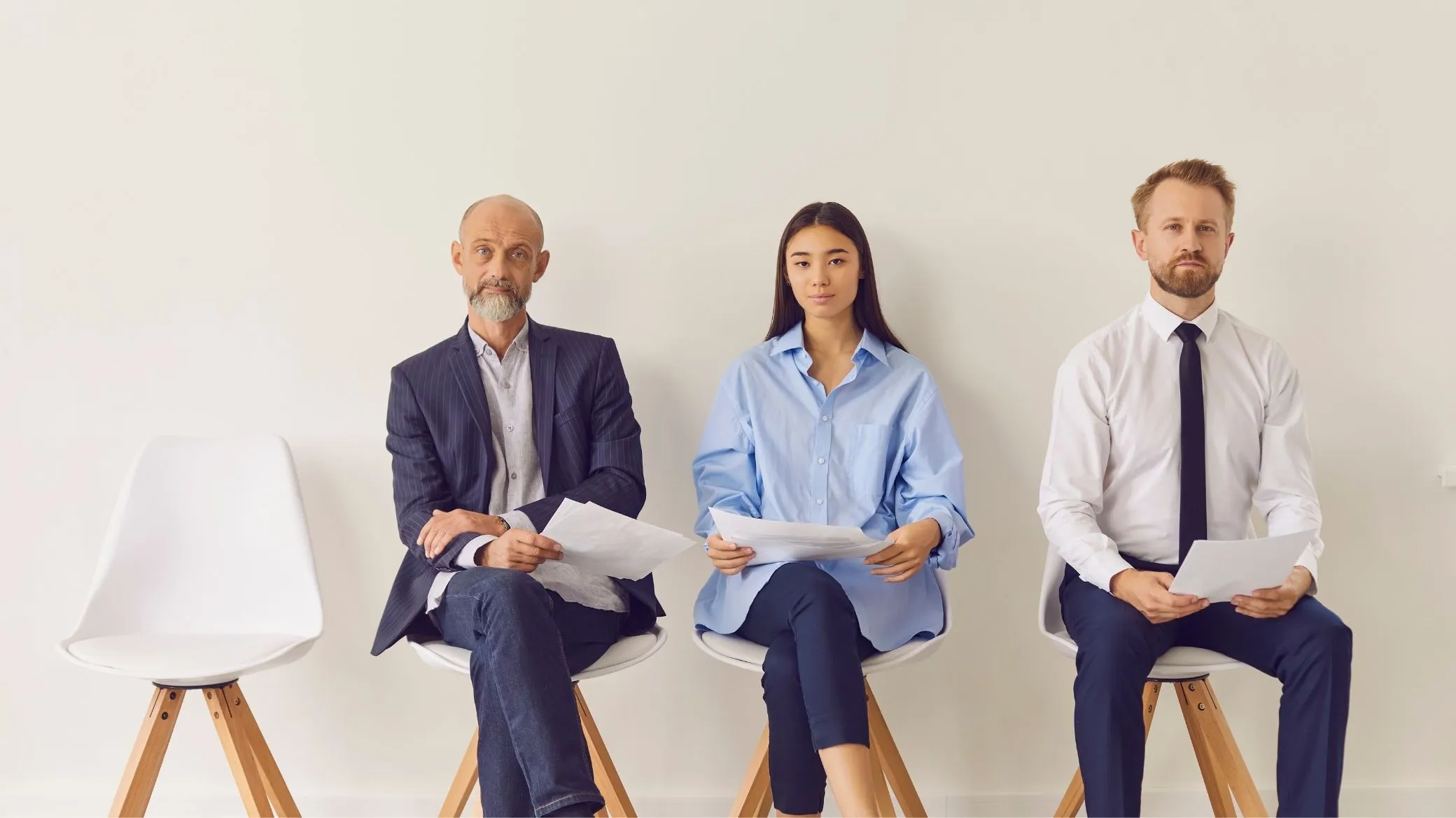Three candidates waiting for their interview, CVs in hand