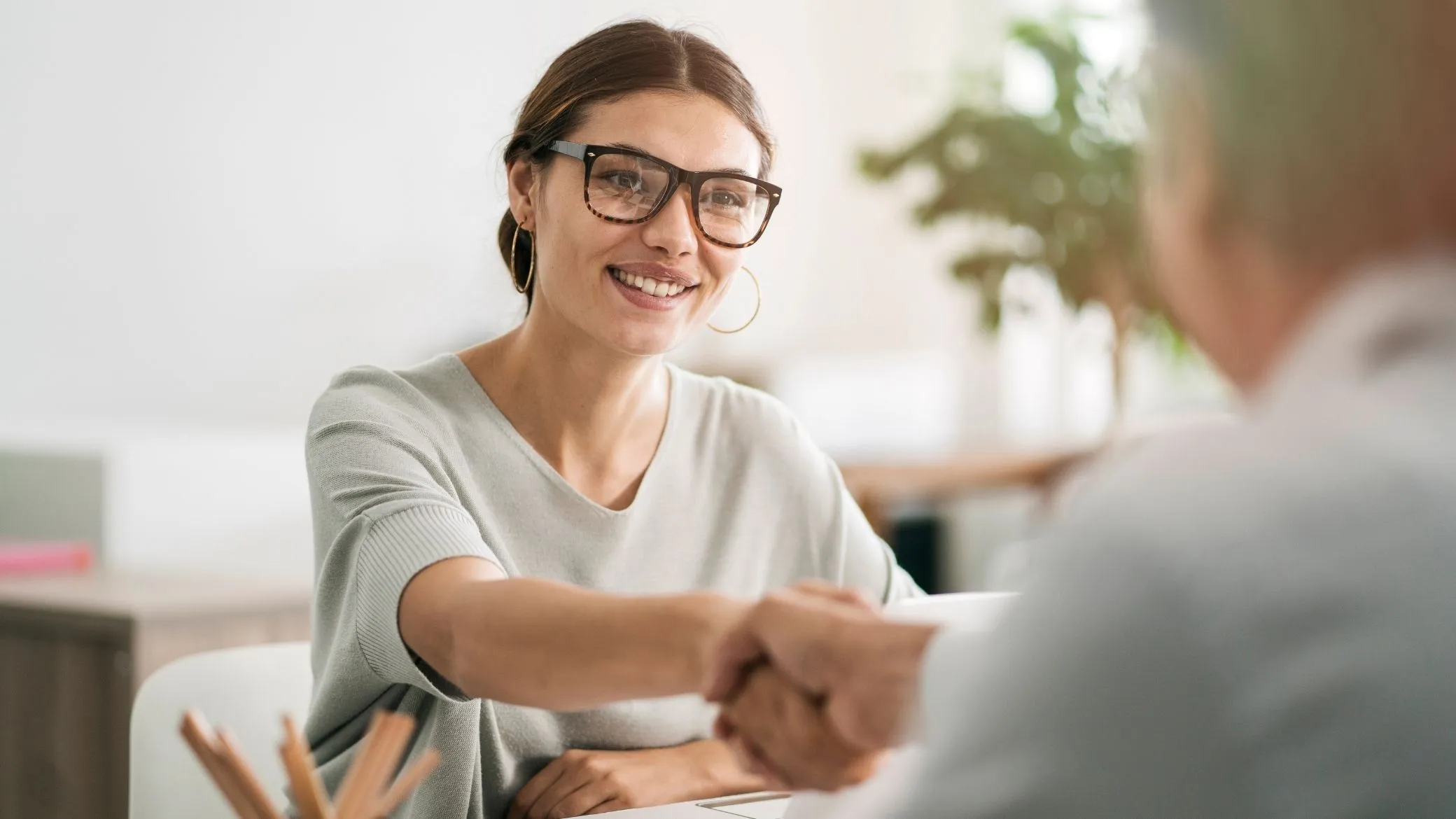 A smiling candidate shaking the interviewer’s hand