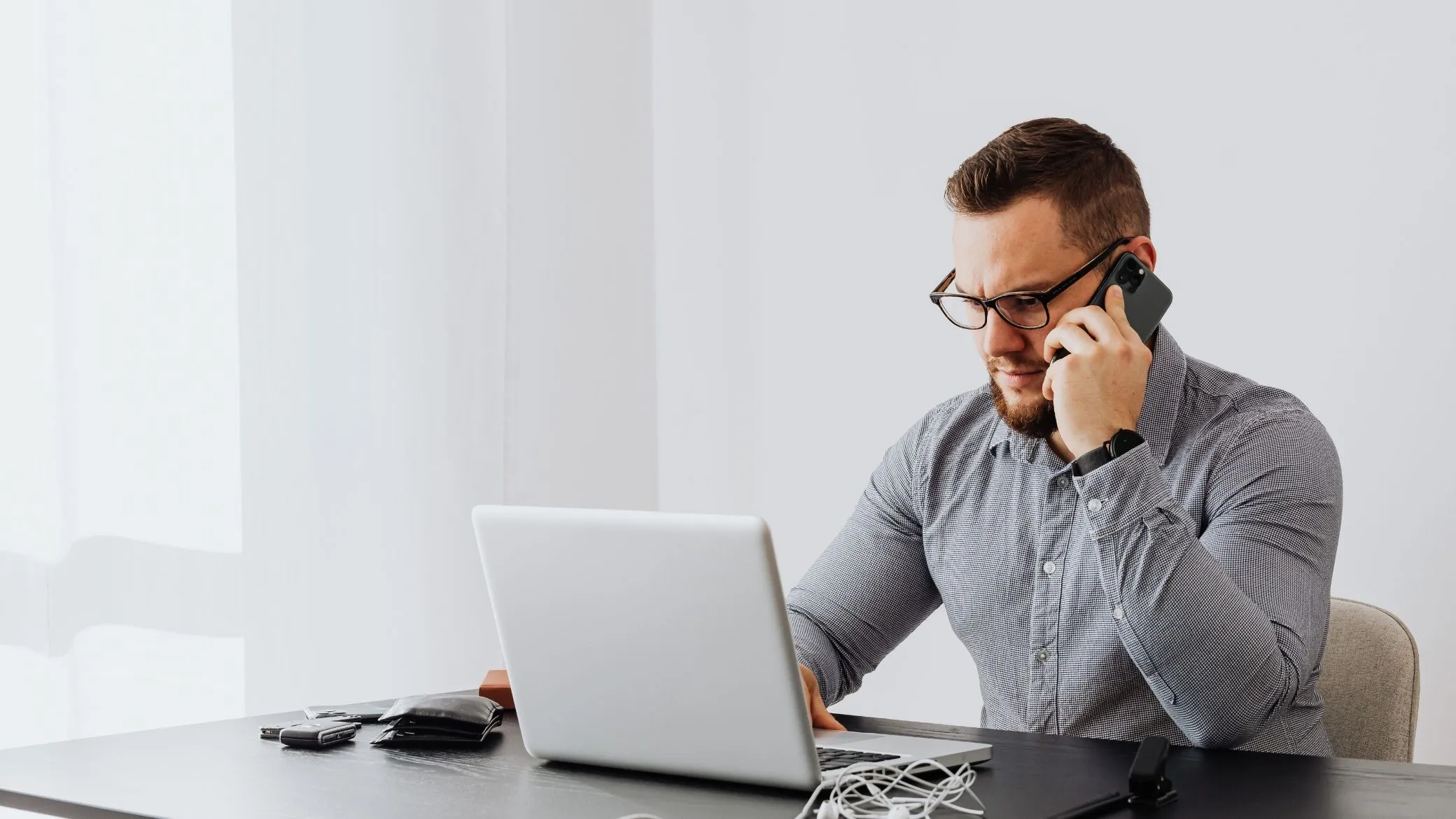 A candidate concentrating on a phone call in front of his laptop